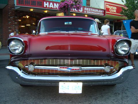 1990 Ford Thunderbird - A classic red Chevrolet is parked on a street in front of a restaurant.