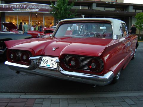 1990 Ford Thunderbird - A classic red Ford Thunderbird from 1959 is displayed with its distinctive rear end and chrome accents.