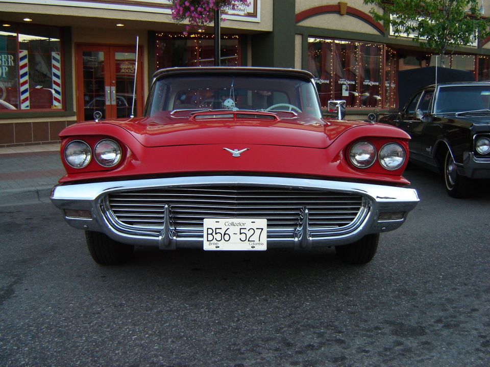 Front view of a red 1959 Ford Thunderbird with a chrome grille and dual headlights. License plate B56-527 is visible