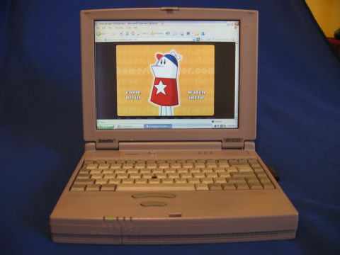 1985 Ford LTD Crown Victoria - A laptop computer is shown open, displaying a website with a cartoon character and options to 'come on in' or 'watch intro'.