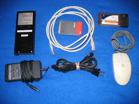 1985 Ford LTD Crown Victoria - Collection of computer accessories including a power adapter, cables, and a mouse.