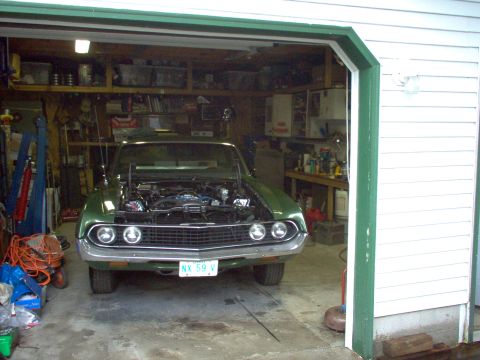 1970 Ford Ranchero - A green 1970 Ford Ranchero is parked inside a garage with its hood open, revealing the engine.