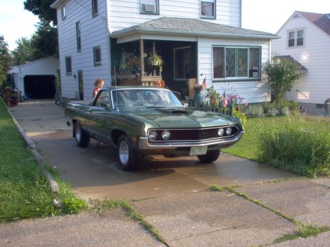 1970 Ford Ranchero - A green 1970 Ford Ranchero is parked in a driveway in front of a house.