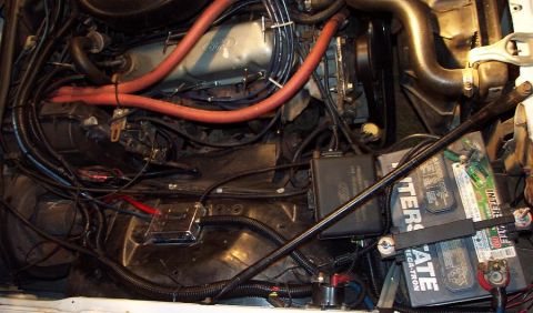 1985 Ford Crown Victoria LTD - Close-up view of a vehicle's engine bay, focusing on the battery and associated wiring.