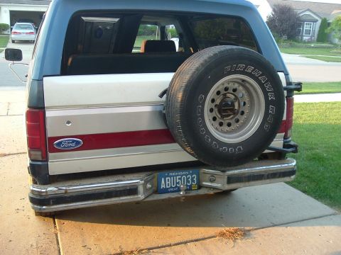 1982 Ford Bronco - The rear of a Ford Bronco shows its spare tire and distinctive body style, suggesting an earlier model year.