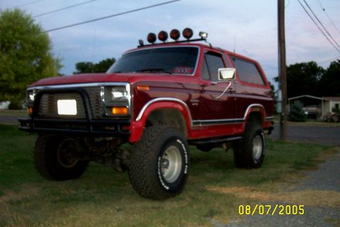 1982 Ford Bronco - This red 1982 Ford Bronco is equipped with a bull bar and multiple lights mounted on the roof rack.