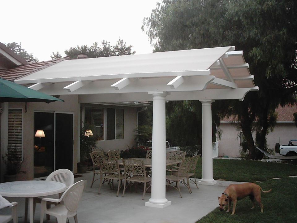 Patio with outdoor dining set, chairs, and a dog on the grass