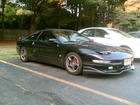 1997 Ford Probe - A black Ford Probe is parked in a lot next to a white car, showing its front 3/4 view.