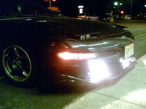1997 Ford Probe - A black sports car is parked at night, its headlights illuminated.