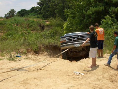 1990 Ford Bronco - Ford F-Series truck stuck in a dirt ditch, with onlookers observing the situation.