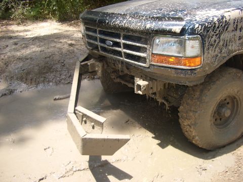 1990 Ford Bronco - Muddy 1990 Ford Bronco front end with custom bumper stuck in a puddle.
