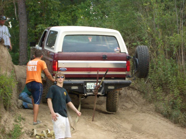 1990 Ford Bronco on a dirt trail with people around it