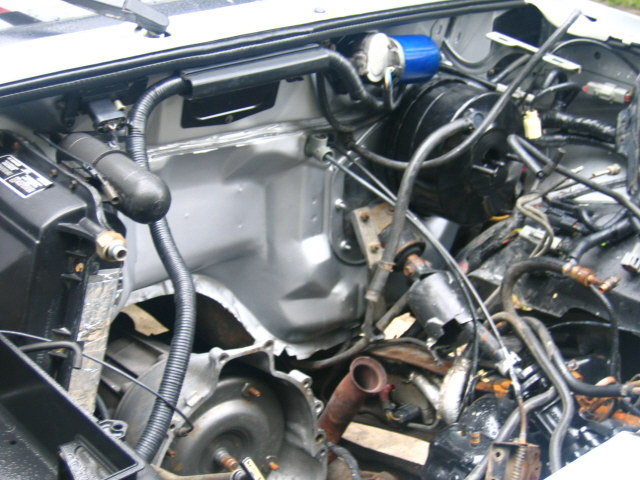 Engine compartment mid-teardown with brake booster, hoses and bare inner fenders