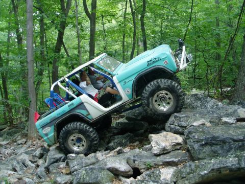 1969 Ford Bronco - This modified 1969 Ford Bronco navigates a challenging rocky terrain in a wooded area.