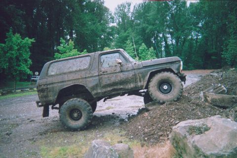 1978 Ford Bronco - Muddy 1978 Ford Bronco navigating an off-road obstacle course.