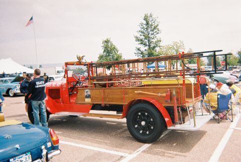 1972 Ford Ranchero - A vintage red fire truck with a wooden bed and ladders is displayed at an outdoor event.