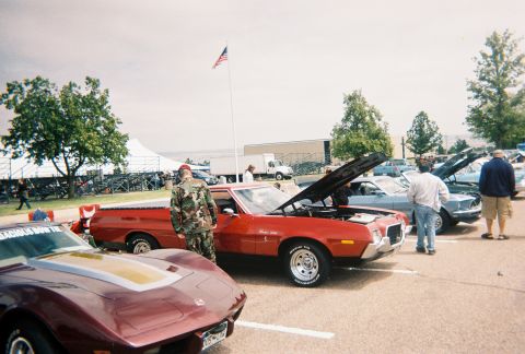 1972 Ford Ranchero - Several cars are parked in a lot with their hoods up, possibly at a car show.