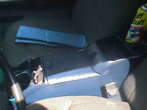 1994 Ford Crown Victoria - The interior of a vehicle shows the center console area with a can of Tuff Stuff cleaner and some blue folded material.