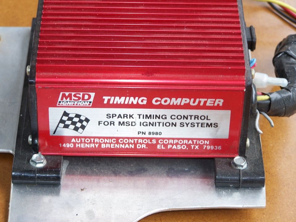 Red MSD Ignition Timing Computer PN 8980 mounted on aluminum bracket on a workbench