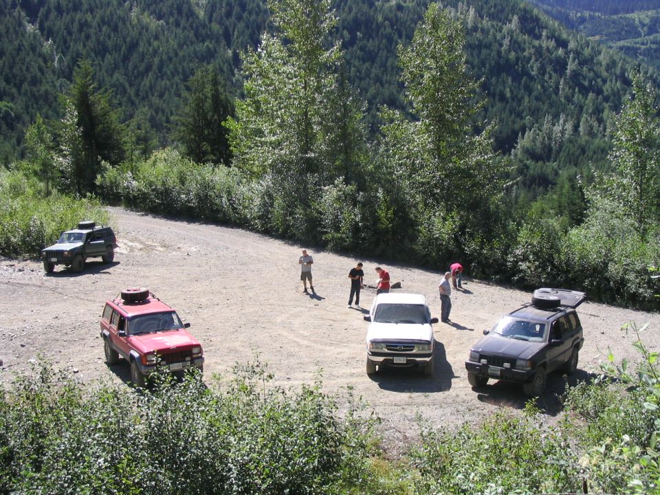 Red 2000 Jeep Cherokee and other SUVs on a mountain road