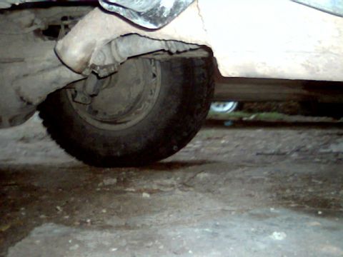 1992 Ford Bronco - Close-up of a vehicle's undercarriage, focusing on the rear wheel and suspension.