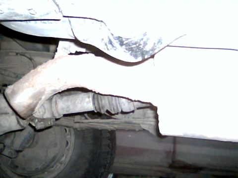 1992 Ford Bronco - Undercarriage view shows a rusty exhaust system and suspension components.