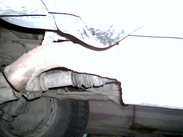 close-up of rusty exhaust pipe and undercarriage components