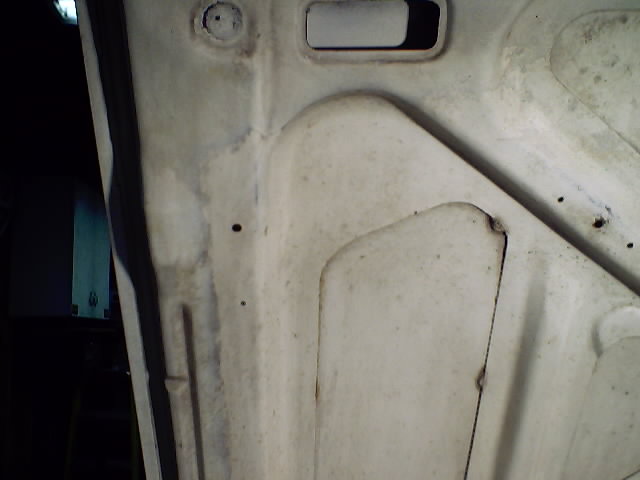 Inner skin of a white vehicle door or panel with access holes and weld seams
