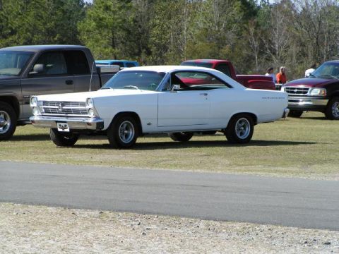 1966 Ford Fairlane - A white 1966 Ford Fairlane is parked on a grassy area with other vehicles nearby.
