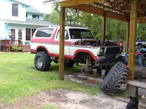 1978 Ford Bronco - This lifted Ford Bronco is parked under a carport with its hood open, suggesting it is undergoing maintenance or modification.