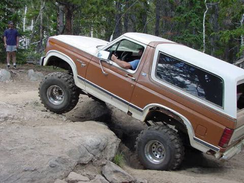 1981 Ford Bronco - This 1981 Ford Bronco navigates a rocky off-road course with a person standing nearby.