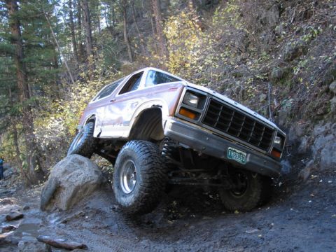 1981 Ford Bronco - This lifted 1981 Ford Bronco navigates a challenging rocky obstacle on an off-road trail.