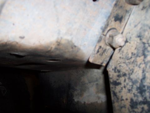 1991 Ford Bronco - A close-up view of a vehicle's undercarriage, showing a bolted metal bracket attached to the frame.
