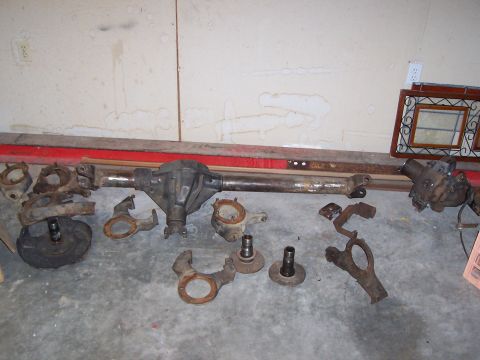 1991 Ford Bronco - Collection of Ford Bronco Dana 44 front axle parts, including the differential housing and steering knuckles.