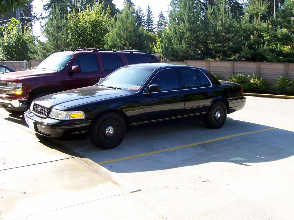 Black 2003 Ford Crown Victoria sedan parked in a lot, front 3/4 view