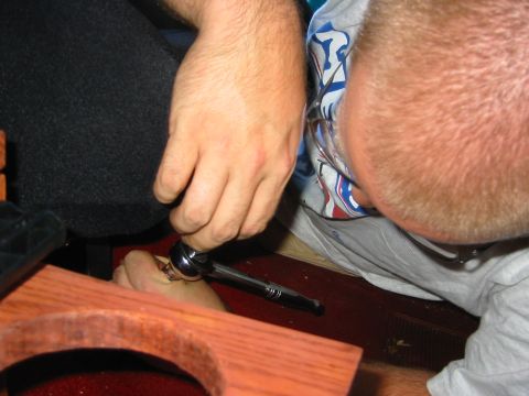1990 Ford Bronco - A person works on the interior of a vehicle, possibly performing a seat swap, with a ratchet tool.