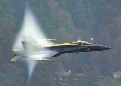 1972 Ford Ranchero - A jet fighter aircraft is captured in a three-quarter front view as it generates a visible vapor cone during flight.