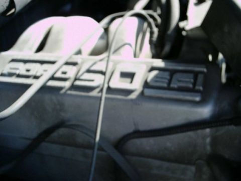 1992 Ford Bronco - Close-up of an engine valve cover showing "302" lettering, with visible wiring and hoses.