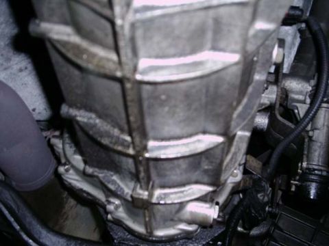 1992 Ford Bronco - Close-up view of a vehicle's transmission housing and exhaust pipe.