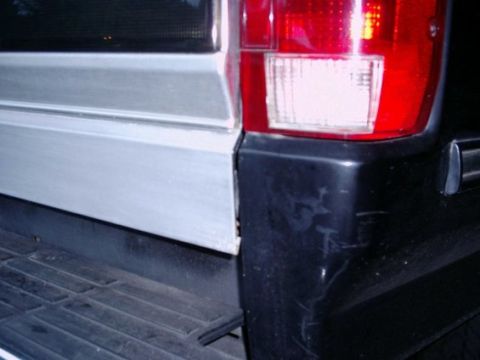 1992 Ford Bronco - The rear corner of the vehicle shows a black bumper and a red taillight assembly.