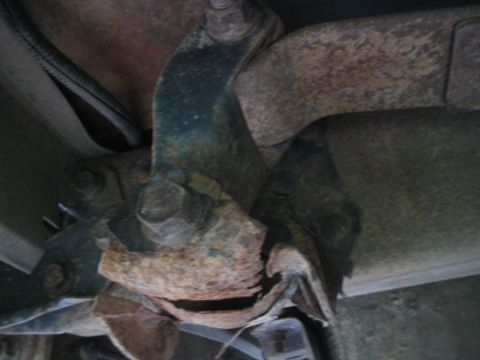1992 Ford Bronco - Close-up view of a severely rusted and broken spring perch, indicating significant wear and potential structural issues.