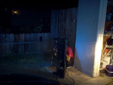 1988 Ford Bronco - A person is working on a metal object, creating sparks, next to a wooden fence and a building.