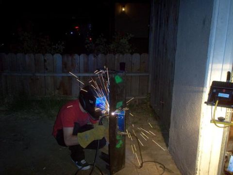 1988 Ford Bronco - A person is welding a metal object outdoors at night, with sparks flying.