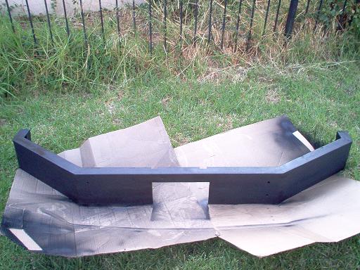 Black aftermarket bumper on cardboard outdoors