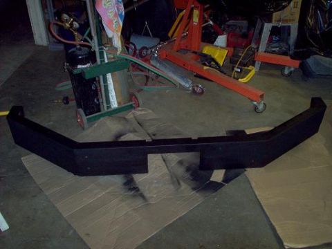 1988 Ford Bronco - Aftermarket front bumper sitting on cardboard in a workshop environment.