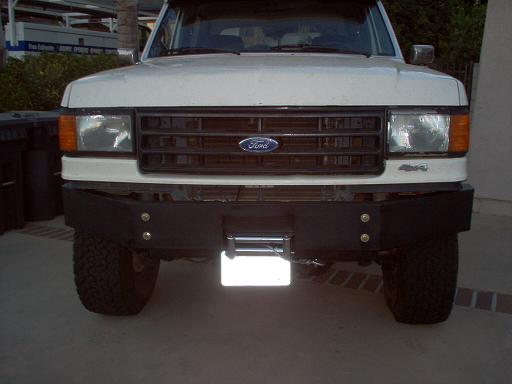 White Ford truck front end with black custom winch bumper and mounted winch
