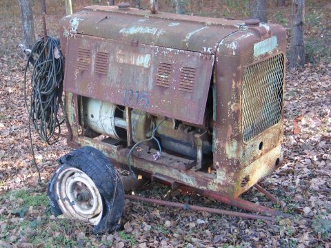 2004 Ford F-150 - This is an old, rusty welding machine with a flat tire and coiled cables, marked with the number 1215.