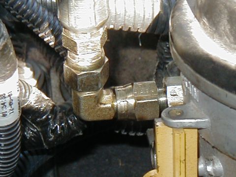 2002 Ford Excursion - A close-up view of a metal fitting on a vehicle's fuel line system, with a date stamp visible on a nearby label.