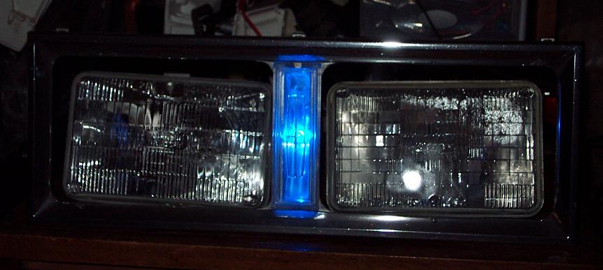 headlight assembly with two rectangular headlights and a vertical blue light in the middle