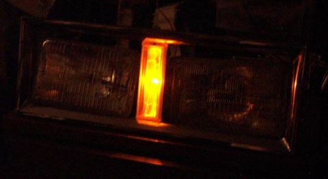 1985 Ford Crown Victoria LTD - Close-up of a vehicle's headlight and amber marker light assembly.